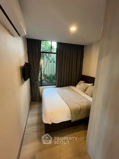 Cozy bedroom with modern decor and garden view, perfect for relaxation.