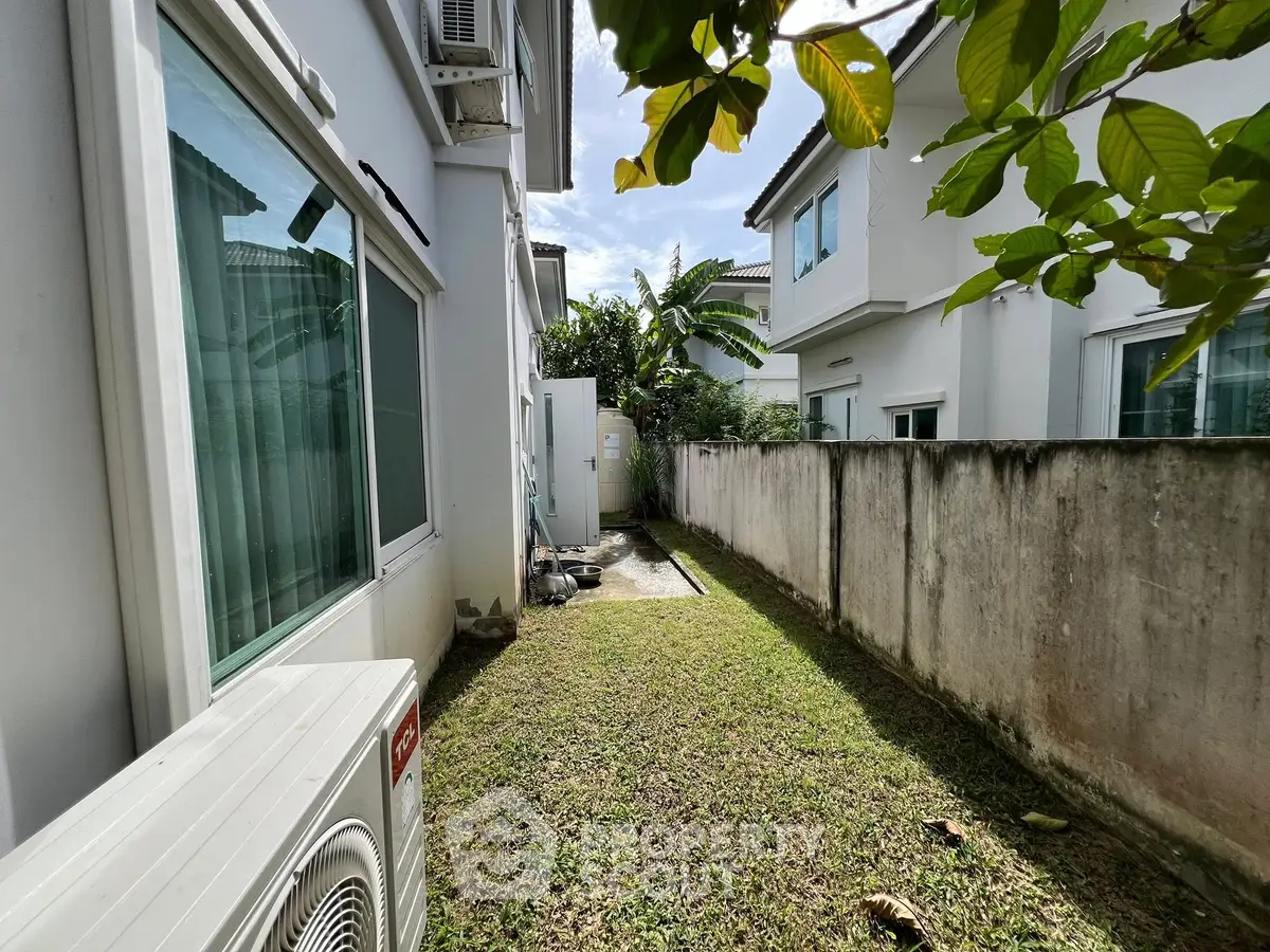 Charming side garden with lush greenery in a modern residential area.