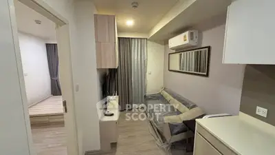 Modern apartment interior with cozy living room and bedroom view, featuring sleek furniture and neutral tones.