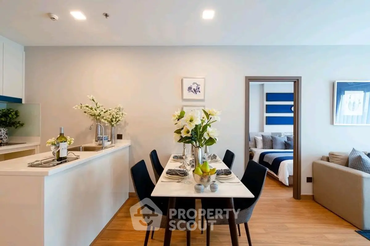 Modern open-plan living and dining area with elegant decor and cozy bedroom view.