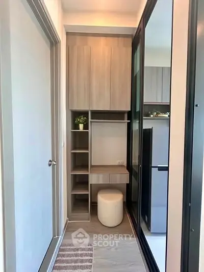 Modern storage area with sleek cabinetry and stool in a contemporary apartment.