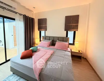 Cozy bedroom with modern decor and ample natural light, perfect for relaxation and comfort.