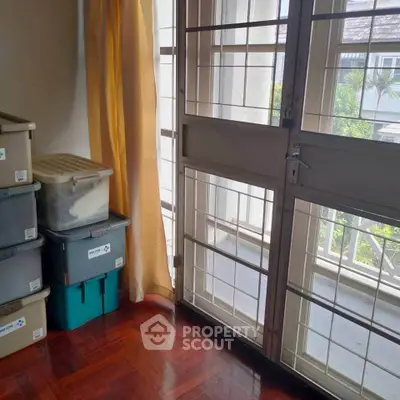 Bright storage room with stacked bins and large window view.