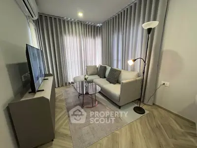 Modern living room with stylish furniture and floor-to-ceiling curtains, perfect for cozy relaxation.