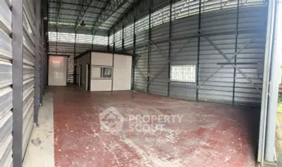 Spacious industrial warehouse with high ceilings and metal walls, ideal for storage or manufacturing.