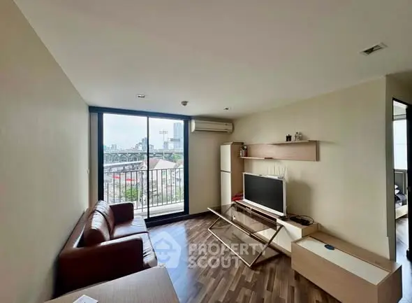 Modern living room with city view, featuring sleek furniture and large windows for natural light.