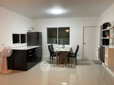Modern kitchen with sleek black cabinets and dining area in open layout