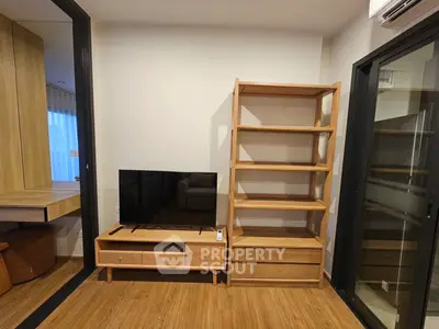 Modern living room with wooden furniture and flat-screen TV, showcasing minimalist design.