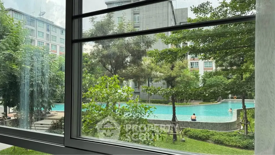 Stunning pool view from a modern apartment window, surrounded by lush greenery and contemporary architecture.
