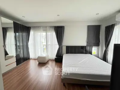 Spacious modern bedroom with large windows and elegant decor