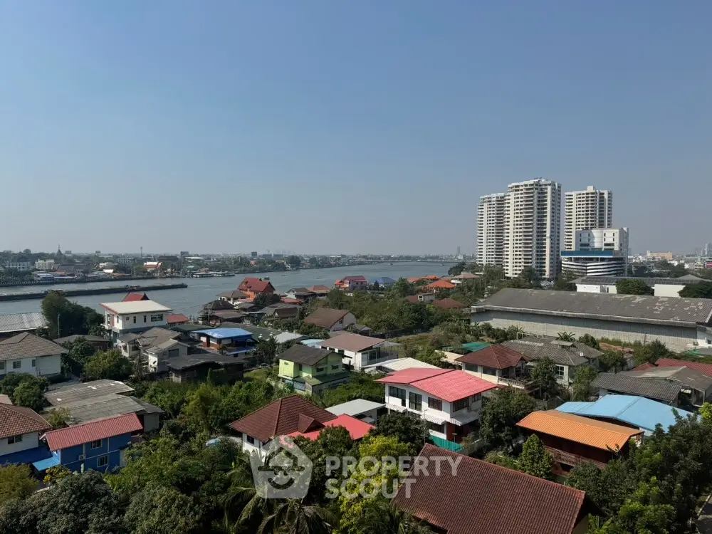 Stunning river view with modern high-rise buildings and colorful rooftops in a vibrant neighborhood.