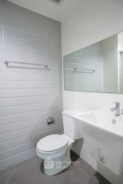Modern bathroom with sleek white tiles and contemporary fixtures.