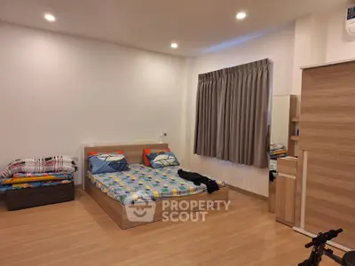 Spacious modern bedroom with wooden flooring and stylish decor