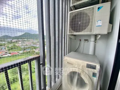 Compact balcony with washing machine and scenic mountain view