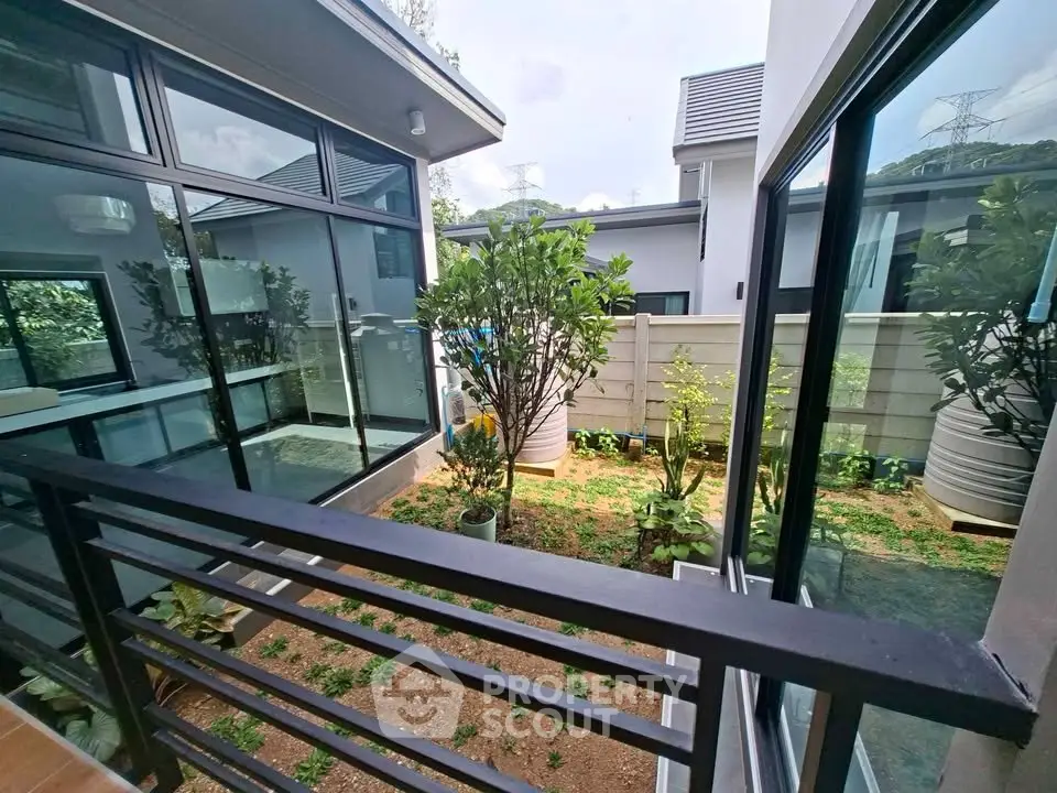 Modern home with glass walls and lush garden view, perfect for nature lovers seeking tranquility.