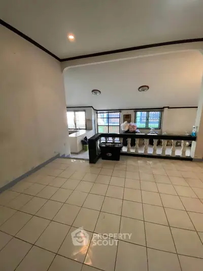 Spacious tiled living area with large windows and open layout, perfect for family gatherings.