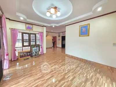 Spacious living room with elegant ceiling design and wooden flooring