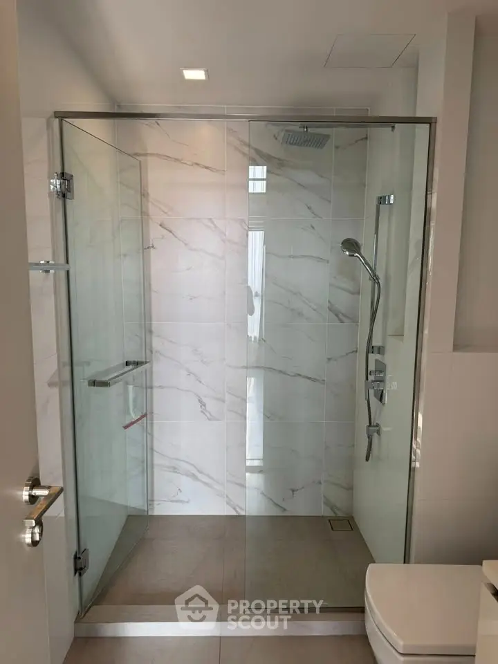 Modern bathroom with glass shower enclosure and sleek fixtures