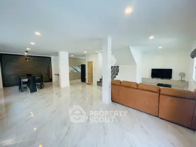Spacious open-plan living room with modern decor and ample natural light.