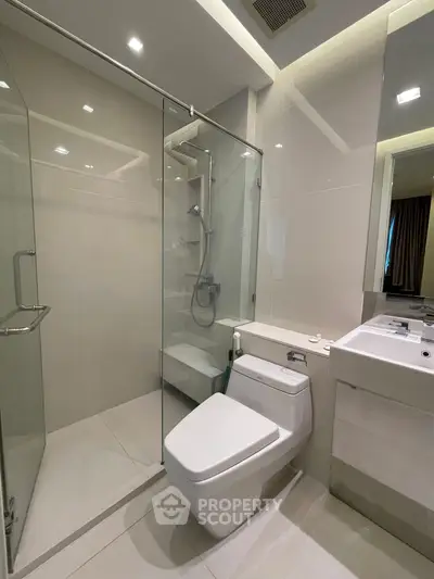 Modern bathroom with glass shower and sleek fixtures in a contemporary apartment.