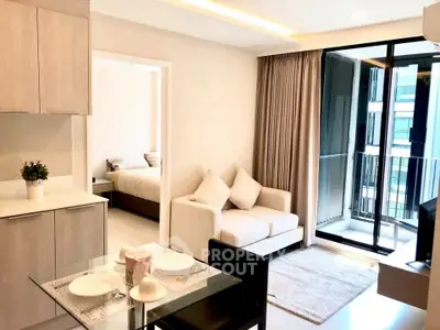 Modern open-plan living room with balcony and cozy bedroom view.