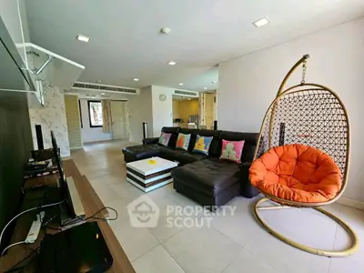 Spacious modern living room with stylish decor and unique hanging chair