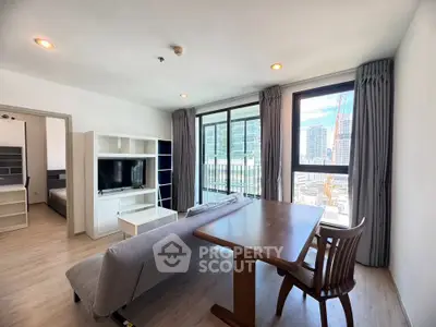 Spacious modern living room with city view, featuring a cozy sofa and dining area.