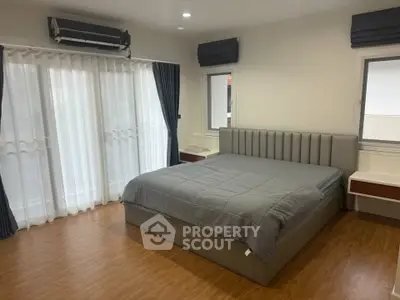 Spacious bedroom with modern design and large windows for natural light.