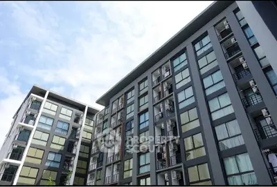 Modern apartment building with sleek design and large windows under a clear blue sky.