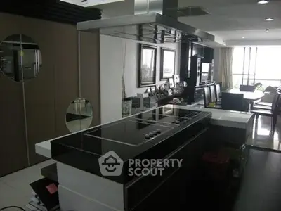 Modern kitchen with sleek black countertops and open layout in stylish apartment.