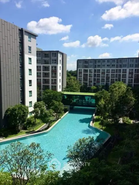 Modern apartment complex with a stunning outdoor pool and lush greenery, perfect for luxury living.