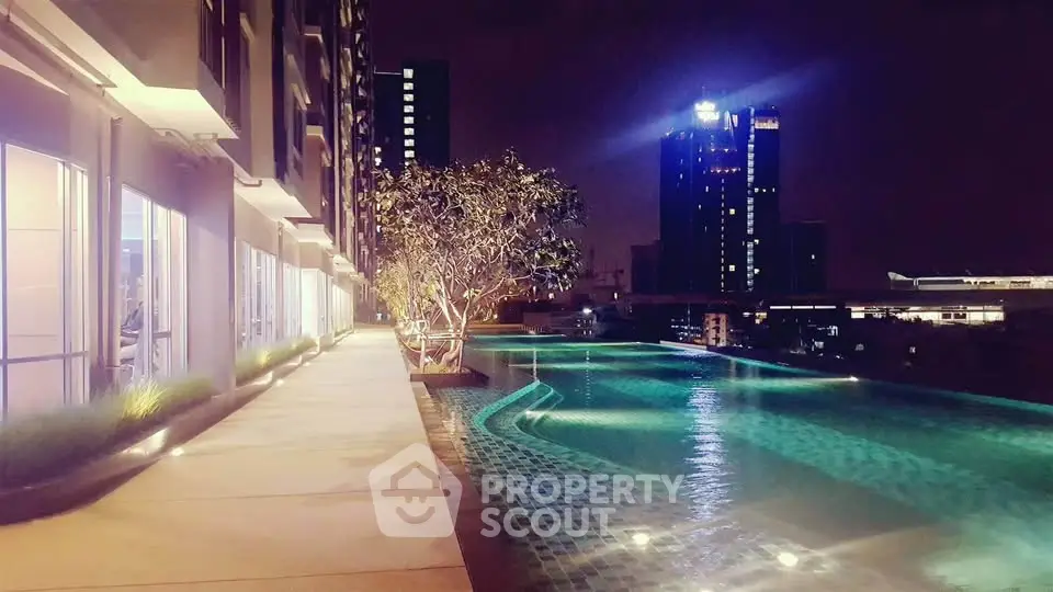 Luxurious rooftop pool with stunning city skyline view at night, perfect for relaxation and entertainment.
