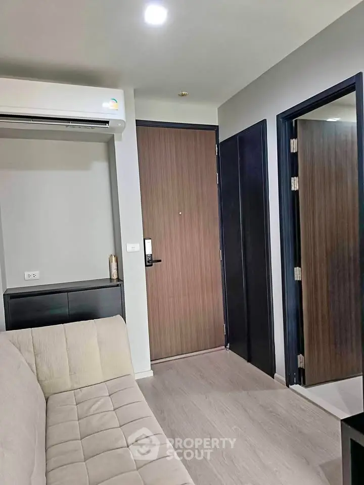Modern apartment interior with sleek design and neutral tones, featuring a comfortable sofa and stylish wooden door.
