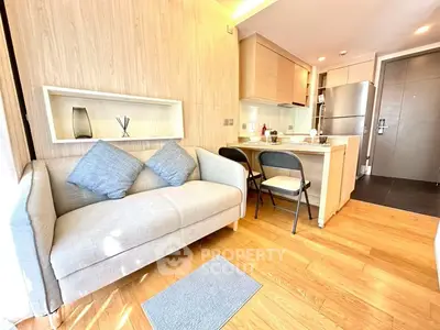 Modern open-plan living room and kitchen with sleek design and natural light.