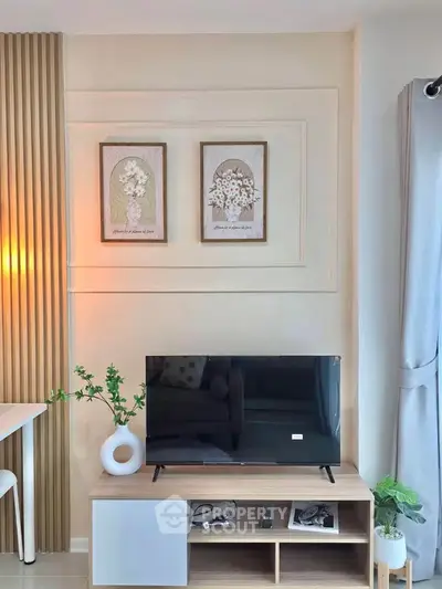 Modern living room with stylish decor and flat-screen TV, perfect for cozy relaxation.