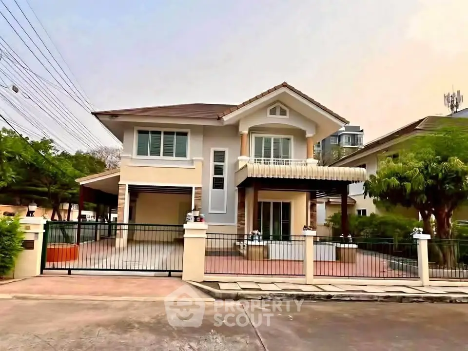 Charming two-story house with gated entrance and lush greenery in a serene neighborhood.