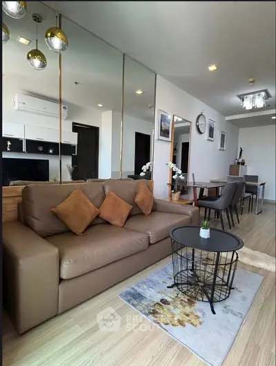 Stylish living room with modern decor, cozy sofa, and elegant dining area in open layout apartment.