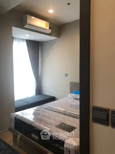 Cozy bedroom with air conditioning and natural light, perfect for relaxation.