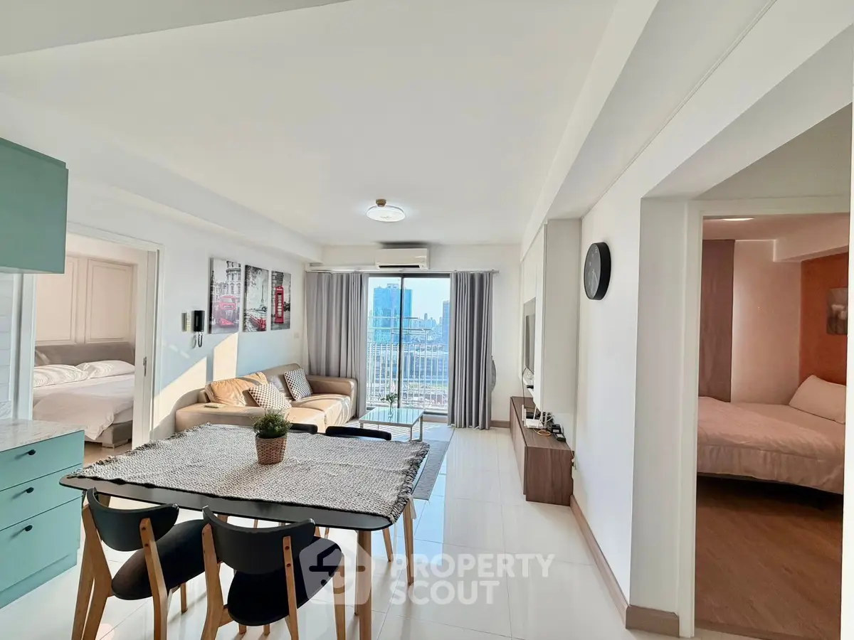 Modern open-plan living room with city view, stylish decor, and dining area.