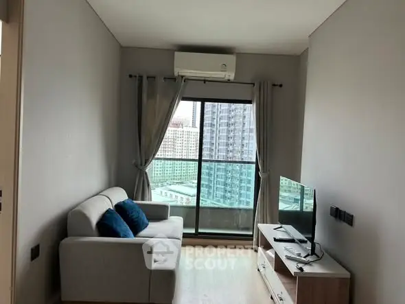 Modern living room with city view, featuring cozy sofa and sleek TV setup.