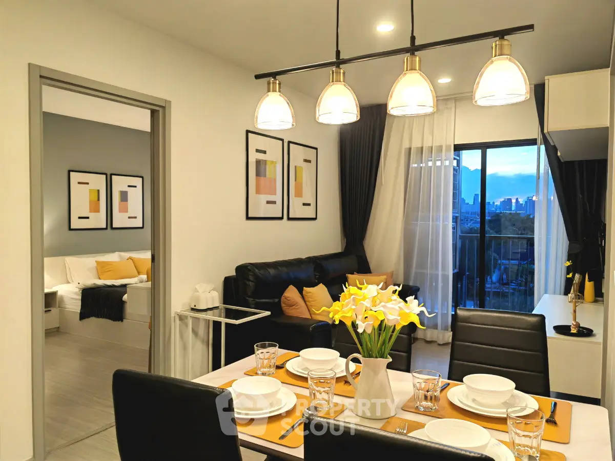 Modern open-plan living and dining area with city view balcony, stylish decor, and elegant lighting.