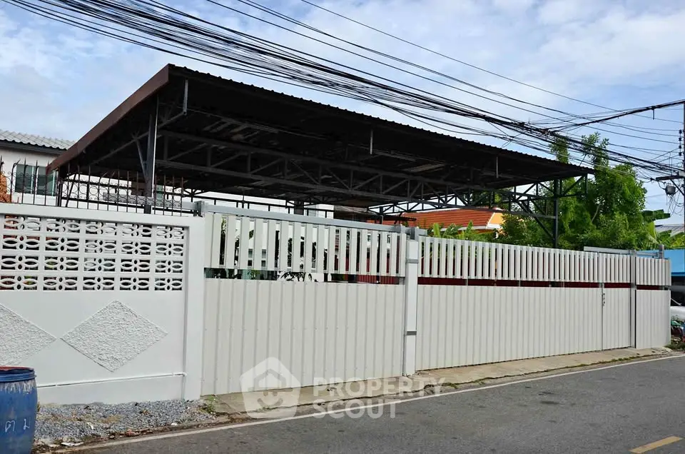 Spacious residential property with gated entrance and covered parking area.