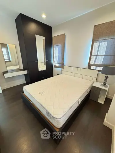 Modern bedroom with sleek dark wood flooring and stylish furniture