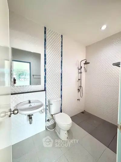 Modern bathroom with sleek fixtures and walk-in shower in a contemporary home.
