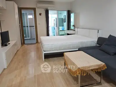 Spacious modern bedroom with cozy seating area and stylish decor