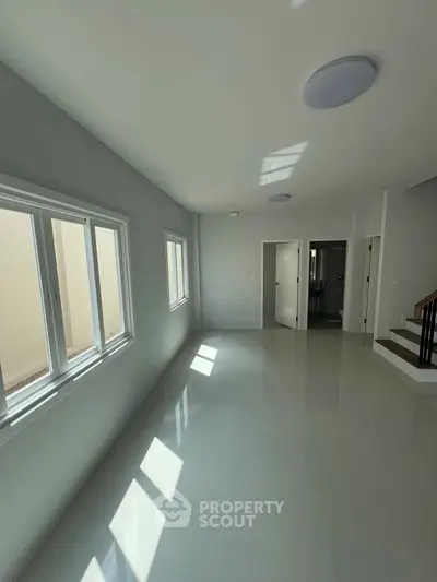 Spacious modern living room with large windows and glossy tiled floor