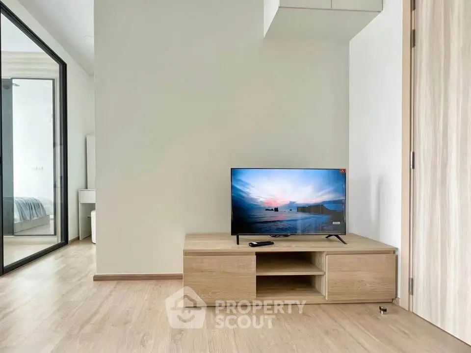 Modern living room with sleek TV stand and wooden flooring, showcasing minimalist design.