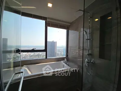 Luxurious bathroom with city view and modern bathtub in high-rise apartment.