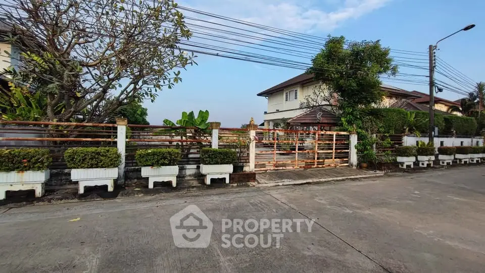 Charming suburban house with lush greenery and spacious driveway in a peaceful neighborhood.