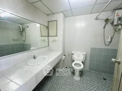 Spacious bathroom with modern fixtures and tiled walls in a real estate property.